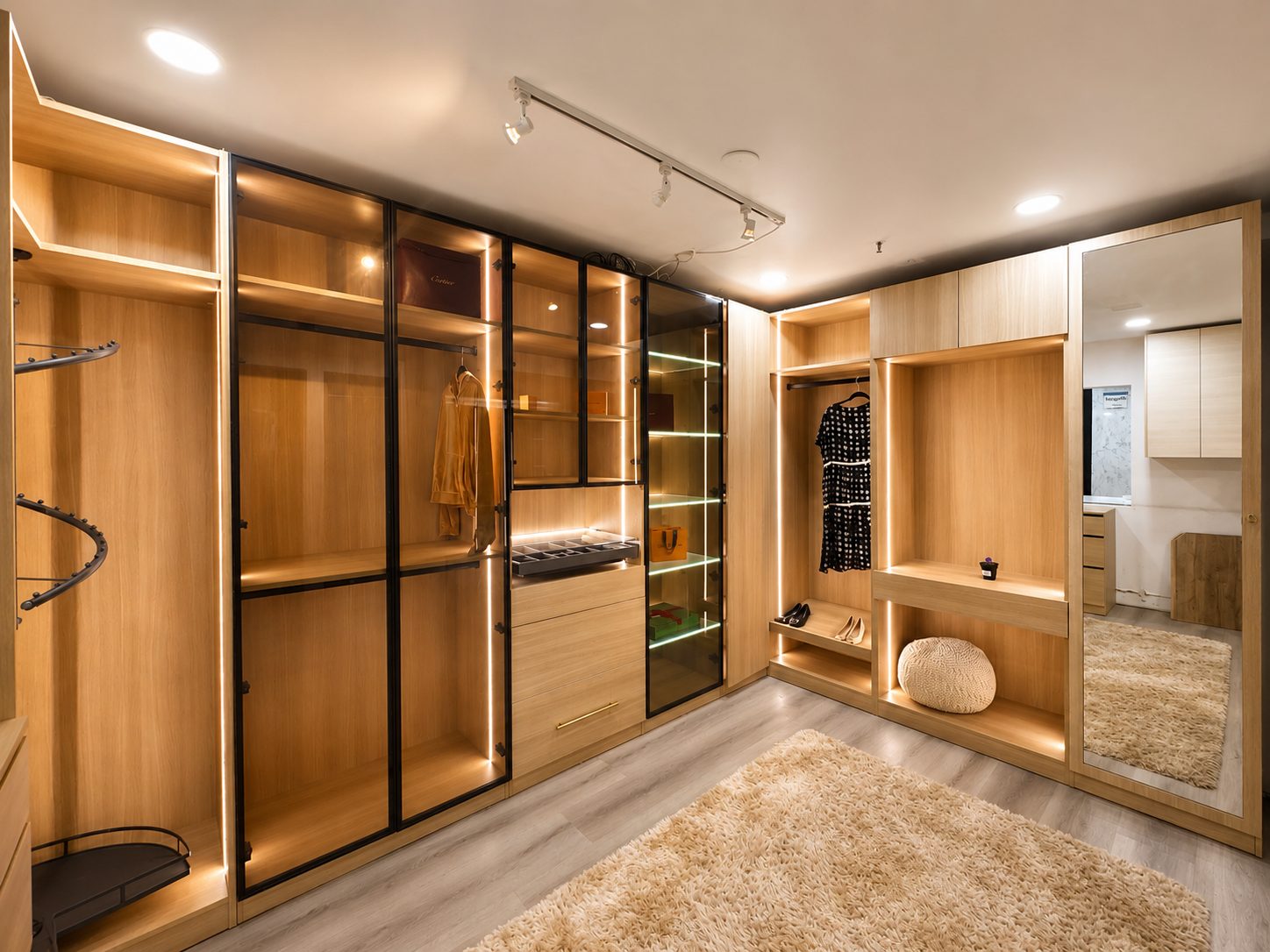 Walk-in oak wardrobe with glass-front cabinets and LED-lit shelving.